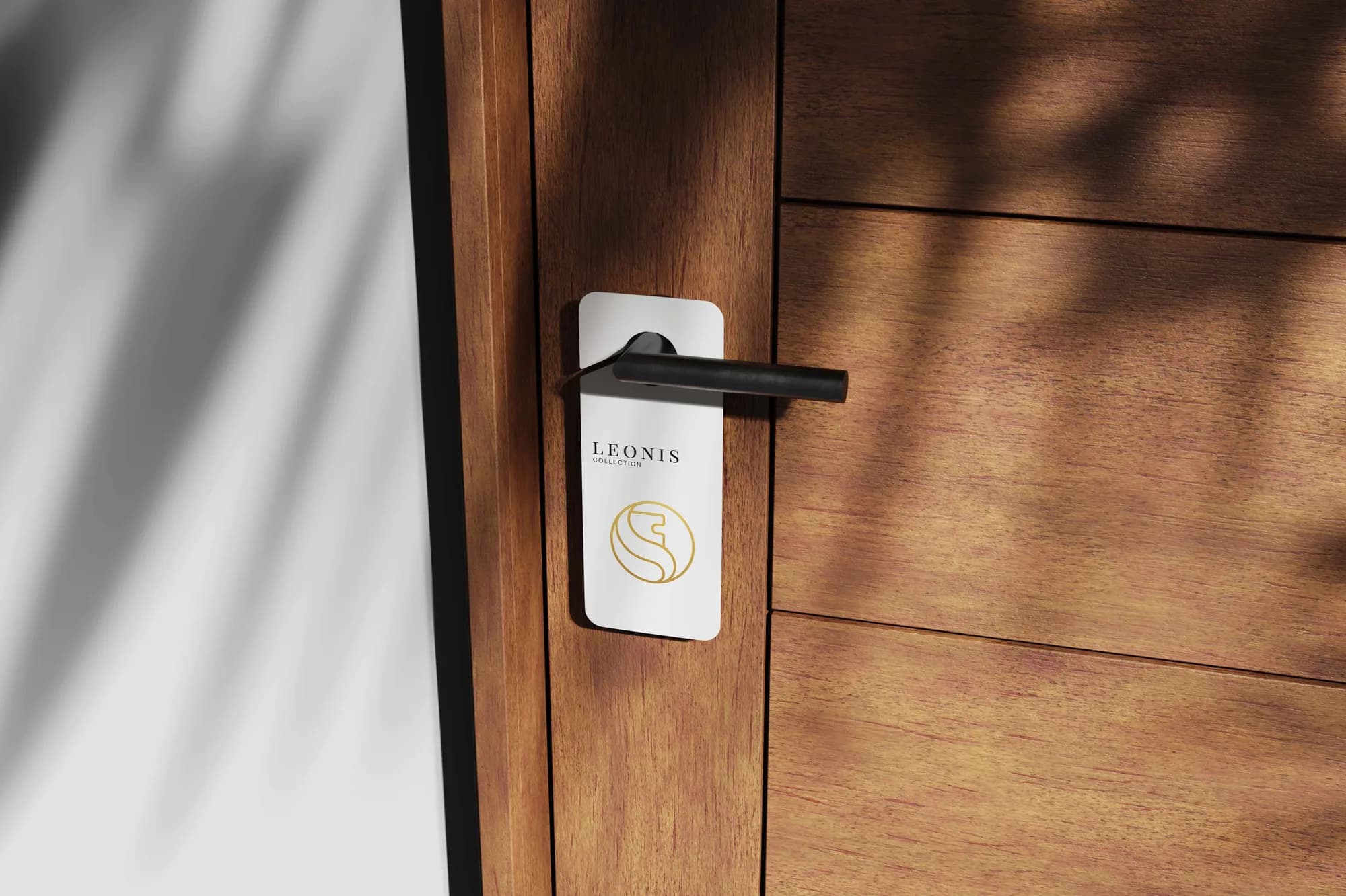 Door hanger on a walnut door handle in raking afternoon light.