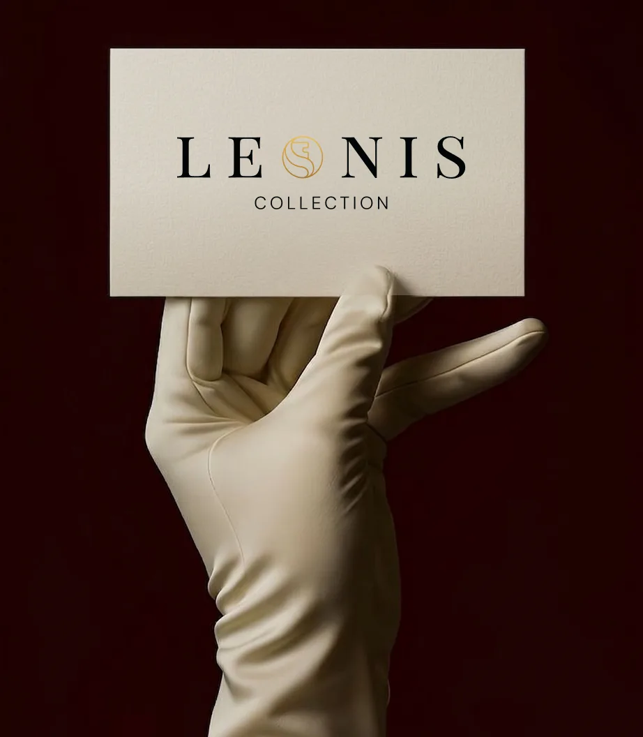 The Leonis business card in a gloved hand against oxblood.